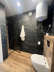 a bathroom with a toilet and a black wall at Marta in Carini +28 photos