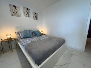 a white bedroom with a bed with blue pillows at Marta in Carini