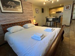a bedroom with a large white bed with towels on it at Studio Rue de Pommard in Francorchamps