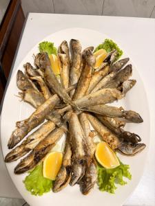 a plate of fish with oranges and lettuce at Hotel-Bar-Riviera in Lezhë