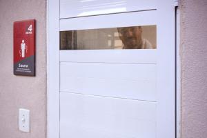 a man is looking out the window of a door at S4 Hotel Águas Claras in Brasília +44 photos