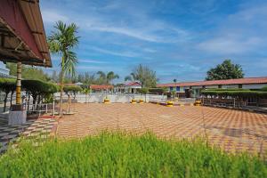 a courtyard with a palm tree and a building at Lake View Village Resort in Tajpur
