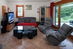 a living room with a couch and chairs and a table at Résidence les Papaillons in Enney