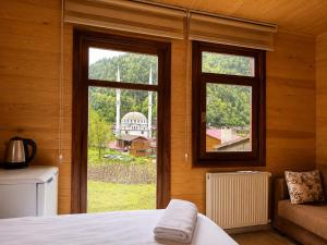 a bedroom with two windows and a bed and a couch at CERRAHPAŞA SUİTE HOTEL in Uzungöl