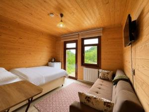 a bedroom with a bed and a couch in a room at CERRAHPAŞA SUİTE HOTEL in Uzungöl