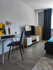 a room with a desk and a chair and a television at Lyra Apartment 2 in Sfântu-Gheorghe