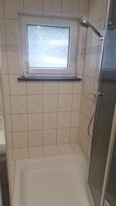 a small bathroom with a window and a shower at Hostel pod Modrzewiem in Świnoujście