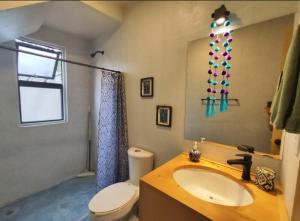 a bathroom with a sink and a toilet and a mirror at Casa Colibri San Cristobal in San Cristóbal de Las Casas +2 photos
