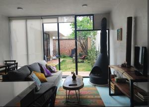 a living room with a couch and a large window at Casa Colibri San Cristobal in San Cristóbal de Las Casas