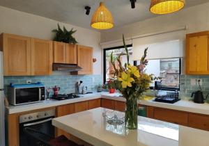 a kitchen with a vase of flowers on a counter at Casa Colibri San Cristobal in San Cristóbal de Las Casas