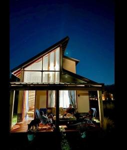 a house with two people sitting in chairs on a patio at cabaña La Ufu 2 in Golondrinas +7 photos