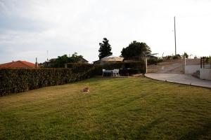 a child sitting in the grass in a yard at Hilltop House Dikella in Alexandroupoli