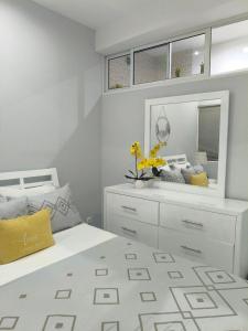 a bedroom with a white bed and a mirror at Cantinho de Mindelo in Mindelo