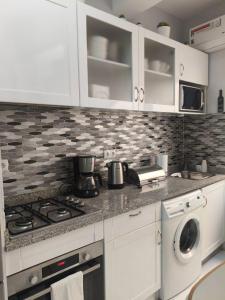 a kitchen with white cabinets and a stove top oven at Cantinho de Mindelo in Mindelo +4 photos
