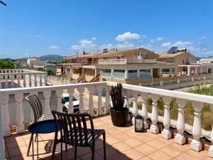 a balcony with two chairs and a table and a fence at Duna Blanca House - Piscina privada - 450m de la playa in Daimuz