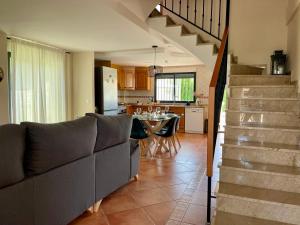 a living room with a couch and a table and a kitchen at Duna Blanca House - Piscina privada - 450m de la playa in Daimuz