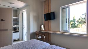 a bedroom with a window and a bed and a chair at SpilGaia in Spílion
