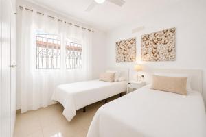 two beds in a white room with two windows at CHALET 83 con PISCINA PRIVADA in Callao Salvaje +4 photos