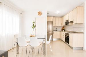a kitchen with a dining table and white chairs at CHALET 83 con PISCINA PRIVADA in Callao Salvaje