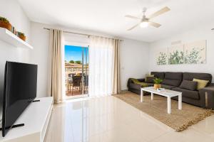 a living room with a couch and a tv at CHALET 83 con PISCINA PRIVADA in Callao Salvaje