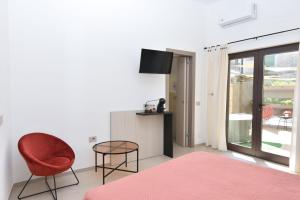 ein Schlafzimmer mit einem roten Stuhl und einem Tisch in der Unterkunft OSprittHouse in Agerola