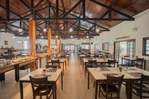 a restaurant with wooden ceilings and tables and chairs at Matiz Igaratá Resort, Spa e Eventos in Igaratá