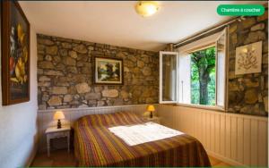 a bedroom with a bed and a stone wall at Le mas du goïo in Seillans +29 photos