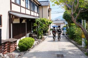 two soldiers walking down a street with an umbrella at 全5室の小さな温泉旅館 別府鉄輪温泉 萬力屋 in Beppu