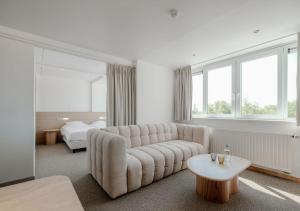 a white living room with a couch and a bed at Duindomein Ter Helme in Oostduinkerke