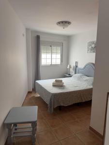 a bedroom with a bed and a chair and a window at Turquesa Zon & Strand Carihuela in Torremolinos