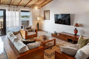 a living room with a couch and a tv at Royal Horizon Baobab in Somone