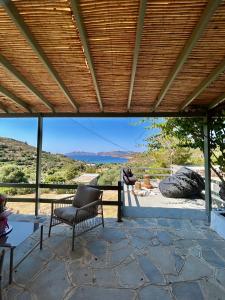 a patio with a chair and a view of the mountains at Theochloe Patmos House in Patmos