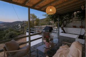 a patio with chairs and a table and a chandelier at Theochloe Patmos House in Patmos