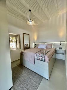 a bedroom with a bed in a white room at Theochloe Patmos House in Patmos