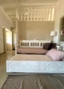 a bedroom with a large white bed with pink pillows at Theochloe Patmos House in Patmos +6 photos