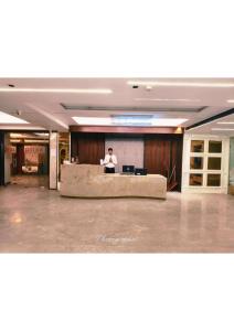 a man standing at a desk in a lobby at Hotel Raaj Palace in Agra