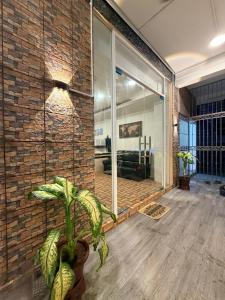 a living room with a brick wall and a plant at OR Stay Semporna in Semporna
