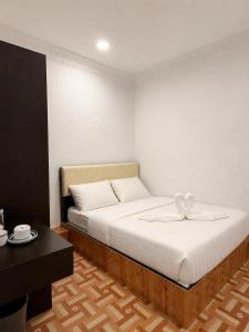 a bedroom with a large bed with white sheets at OR Stay Semporna in Semporna +16 photos