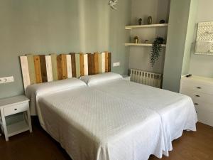 a bedroom with two beds with white sheets at Casa La Campa in Comillas