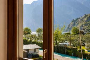 a window with a view of a river and mountains at Appartamento Brione Lido in Nago-Torbole