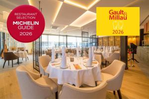 a restaurant with white tables and chairs and a sign at Hotel New Skanpol in Kołobrzeg +95 photos