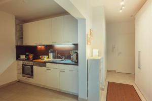 a kitchen with white cabinets and a sink at Sonnentraum in Zinnowitz