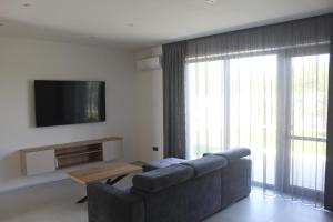 a living room with a couch and a flat screen tv at Apartmány Nitrianska osada in Bánov