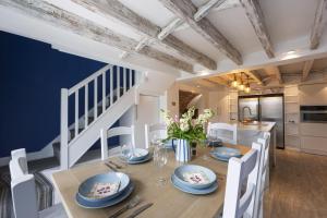 a dining room with a table and chairs and a kitchen at Watch Cottage in Lymington
