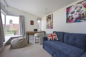 a living room with a blue couch and a table at Watch Cottage in Lymington