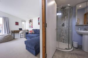 a bathroom with a shower and a blue couch at Watch Cottage in Lymington +49 photos