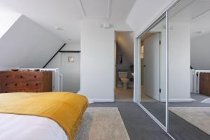 a bedroom with a bed with a yellow blanket at Watch Cottage in Lymington