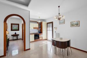 a living room with a table and a kitchen at B&B Pozzuoli - Suite Ermosa in Pozzuoli