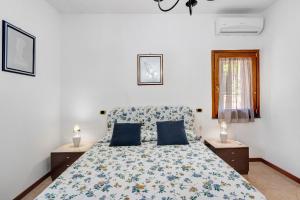 a bedroom with a bed with two blue pillows at B&B Pozzuoli - Suite Ermosa in Pozzuoli +27 photos