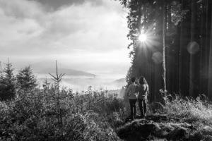 two people standing on a hill with the sun behind them at Apartment Huckelberg in Schmallenberg